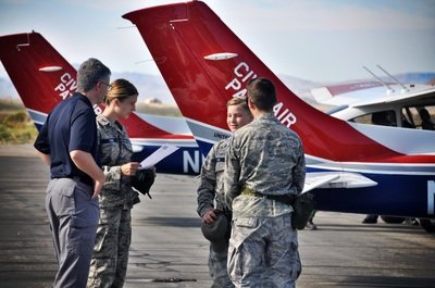 Four members of Civil Air Patrol gathering near an airplane